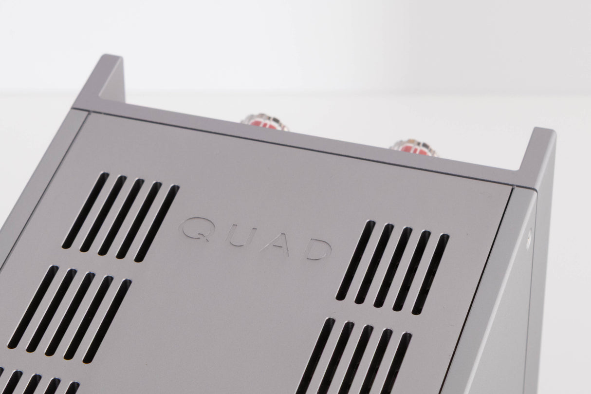 Close up of a used Quad 303 Power Amplifier in a Silver finish showing logo on top