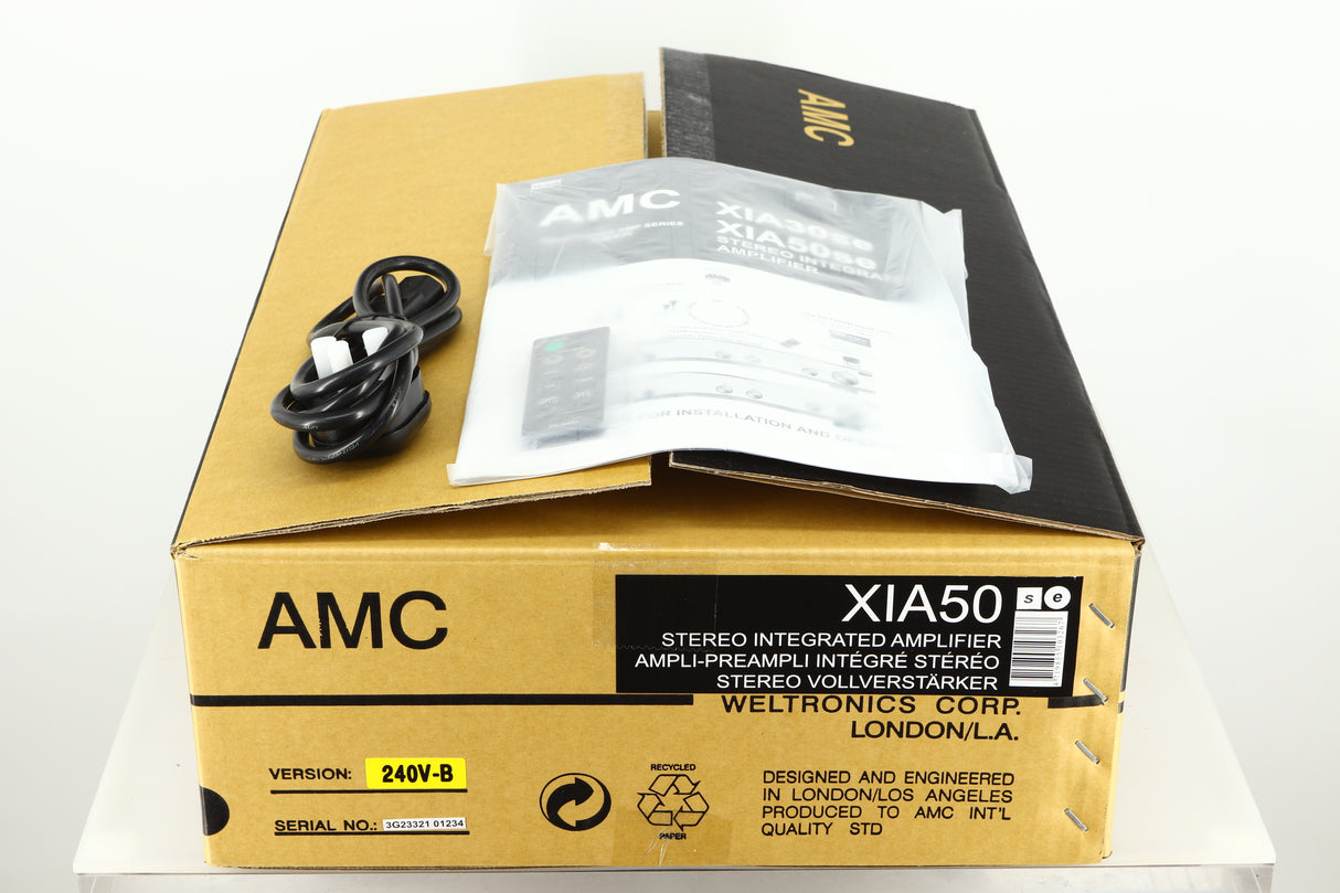 Box of an Ex Demo AMC XIA50 Integrated Amplifier showing mains cable, manual, and remote