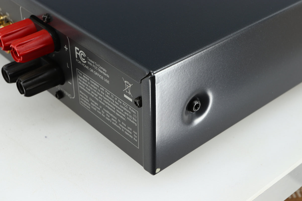 Rear left corner of a used Arcam FMJ A19 Integrated Amplifier in a black finish