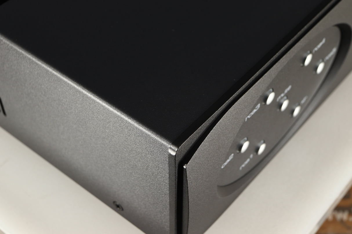 Close up of a used Astin Trew AT2-2100 Integrated Amplifier in a black finish showing very minor graze on front left corner
