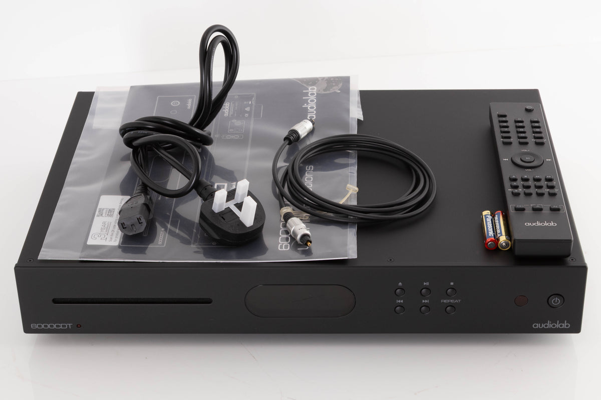 Top of a used Audiolab 6000CDT CD Transport in a Black finish showing Remote, Batteries, Mains Cable, Manual and Optical Cable