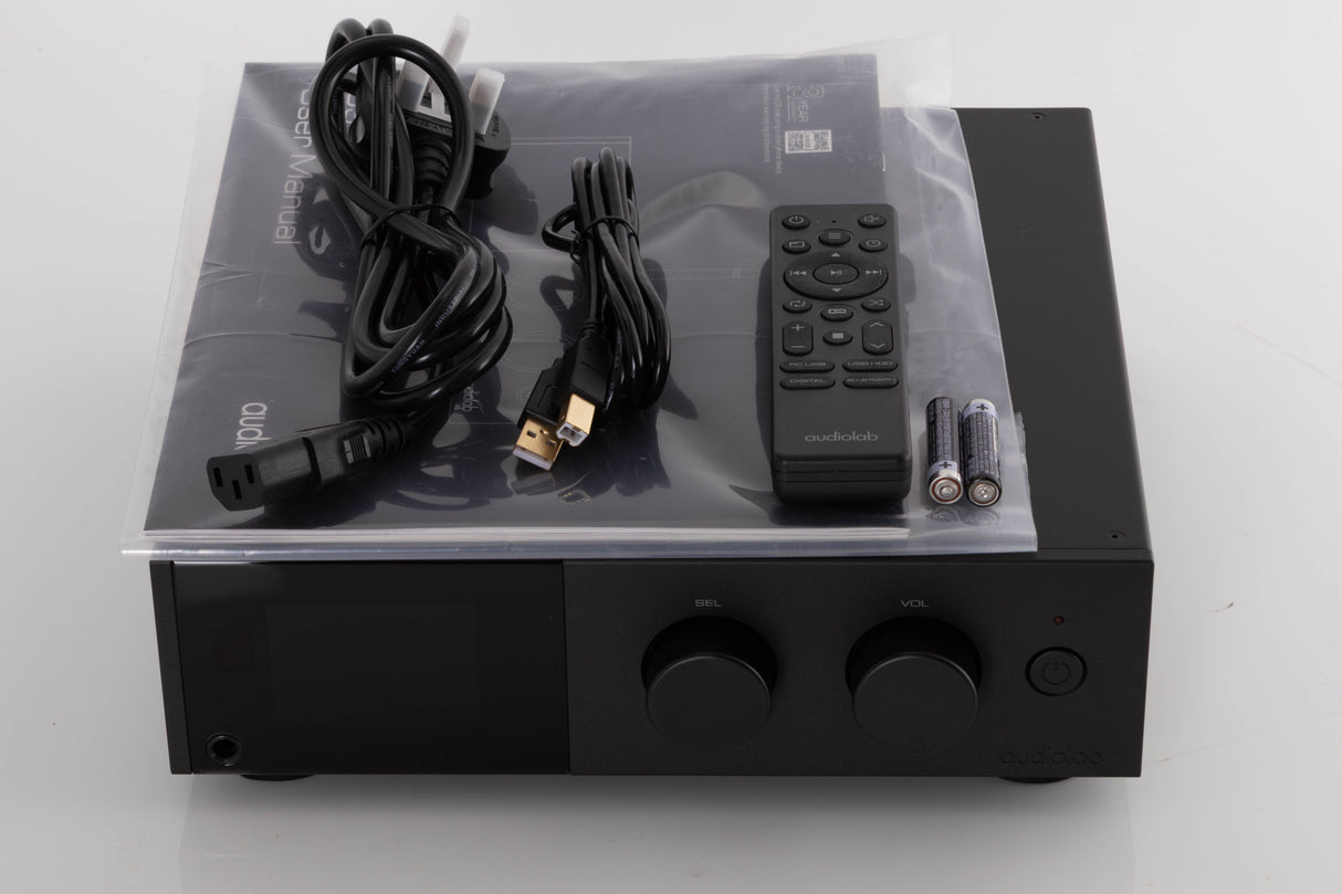 Top of a used Audiolab D9 Digital Analogue Converter in a Black finish showing Manual, Remote, Batteries, Mains Cable and USB Cable
