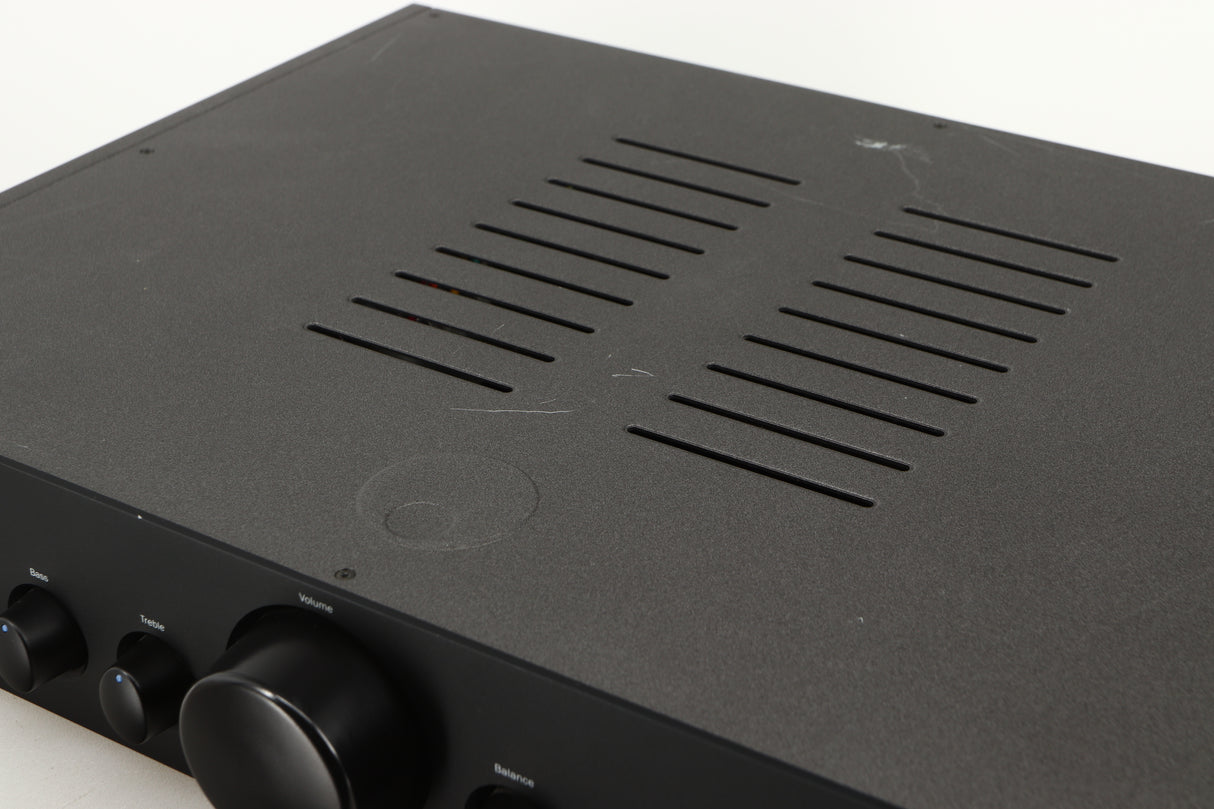 Close up of a used Cambridge Audio 340A Integrated Amplifier in a black finish showing scratching on top