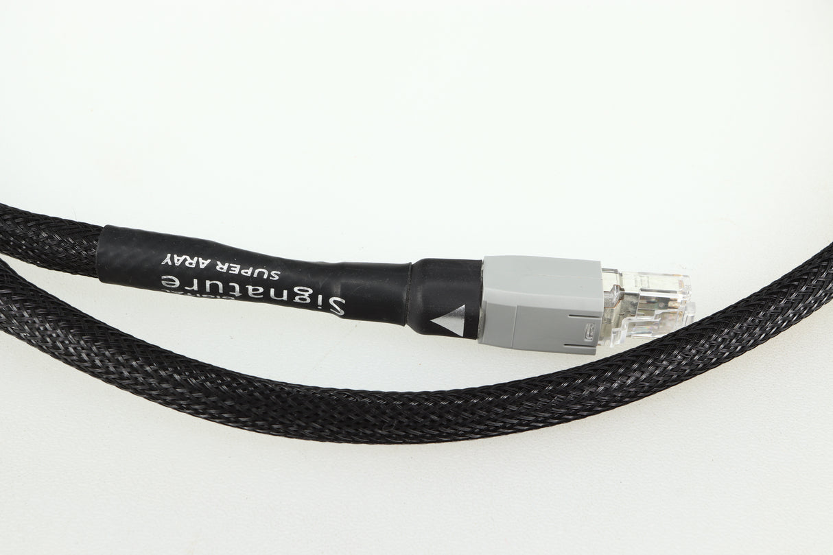 Close up of a used Chord Company Signature Super Aray Digital Streaming Cable 1.0m in a black finish showing the connector