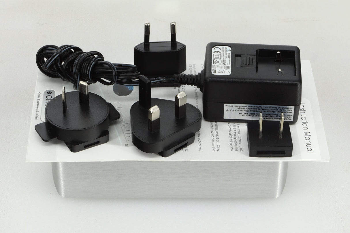 Top view of a used Chord Electronics 2Qute Digital Analogue Converter in a silver finish showing a power supply, mains plug, manual and 3x schuko plugs