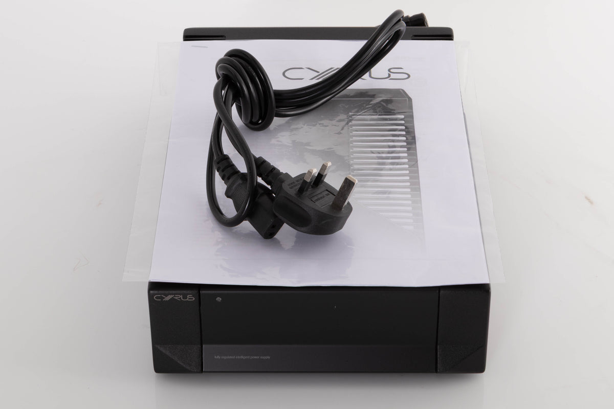 Top of a used Cyrus PSX-R2 Power Supply in a Brushed Black finish showing Mains Cable and Manual