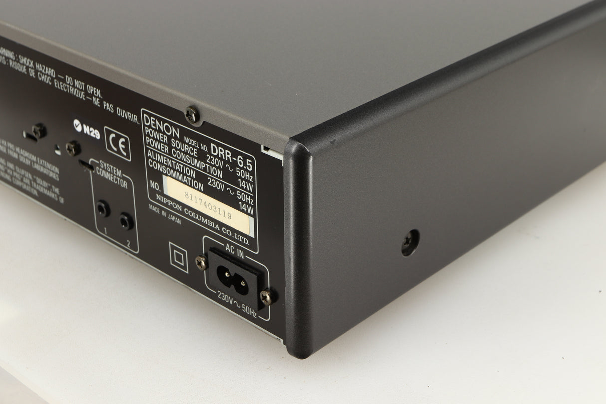 Rear left corner of a used Denon DDR-6.5 Cassette Deck in a silver finish