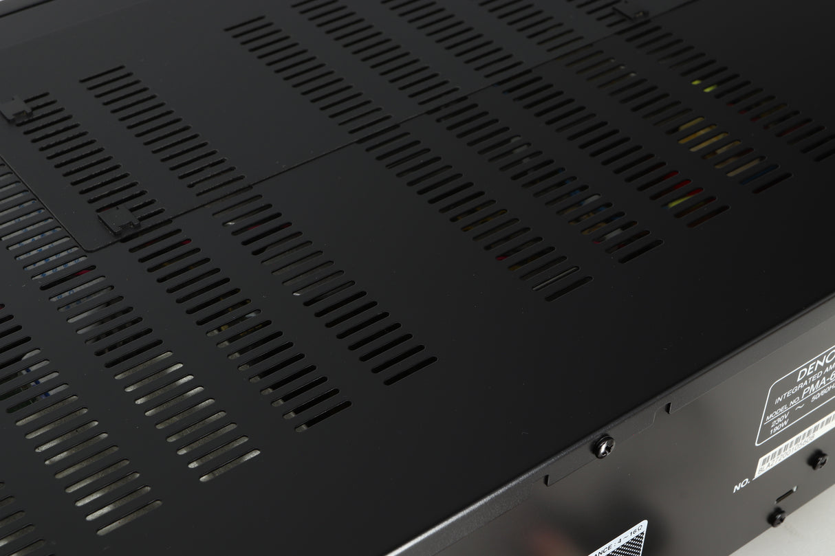 Close up of a used Denon PMA600 Integrated Amplifier in a black finish showing some light scratching on top