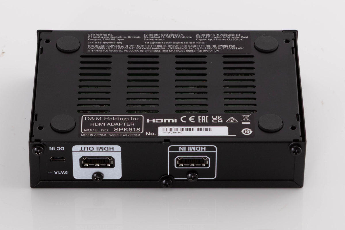 Underside of a used Denon SPK618 HDMI Adaptor in a Black finish