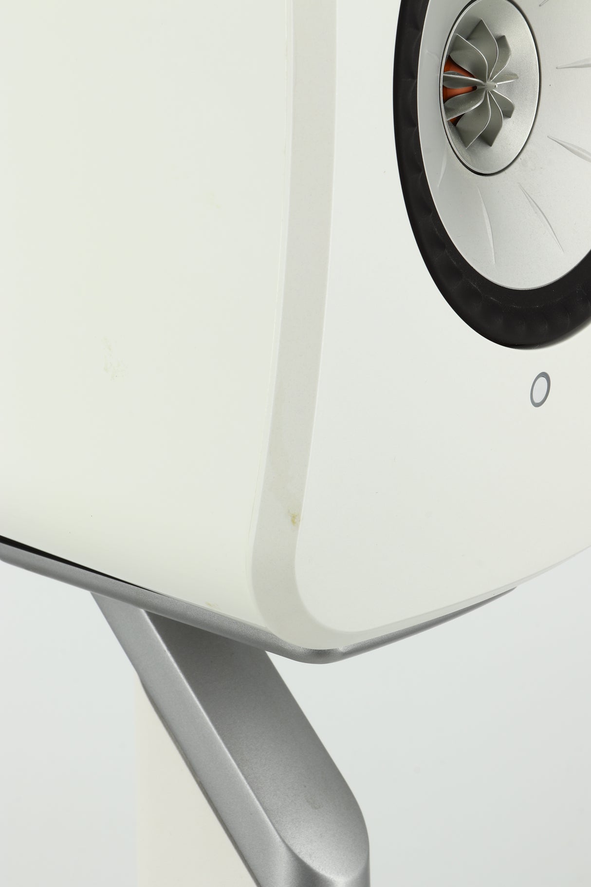 Close up of a used KEF LSX Standmount Speaker W/ Stand in a white finish showing a small mark on front left egde