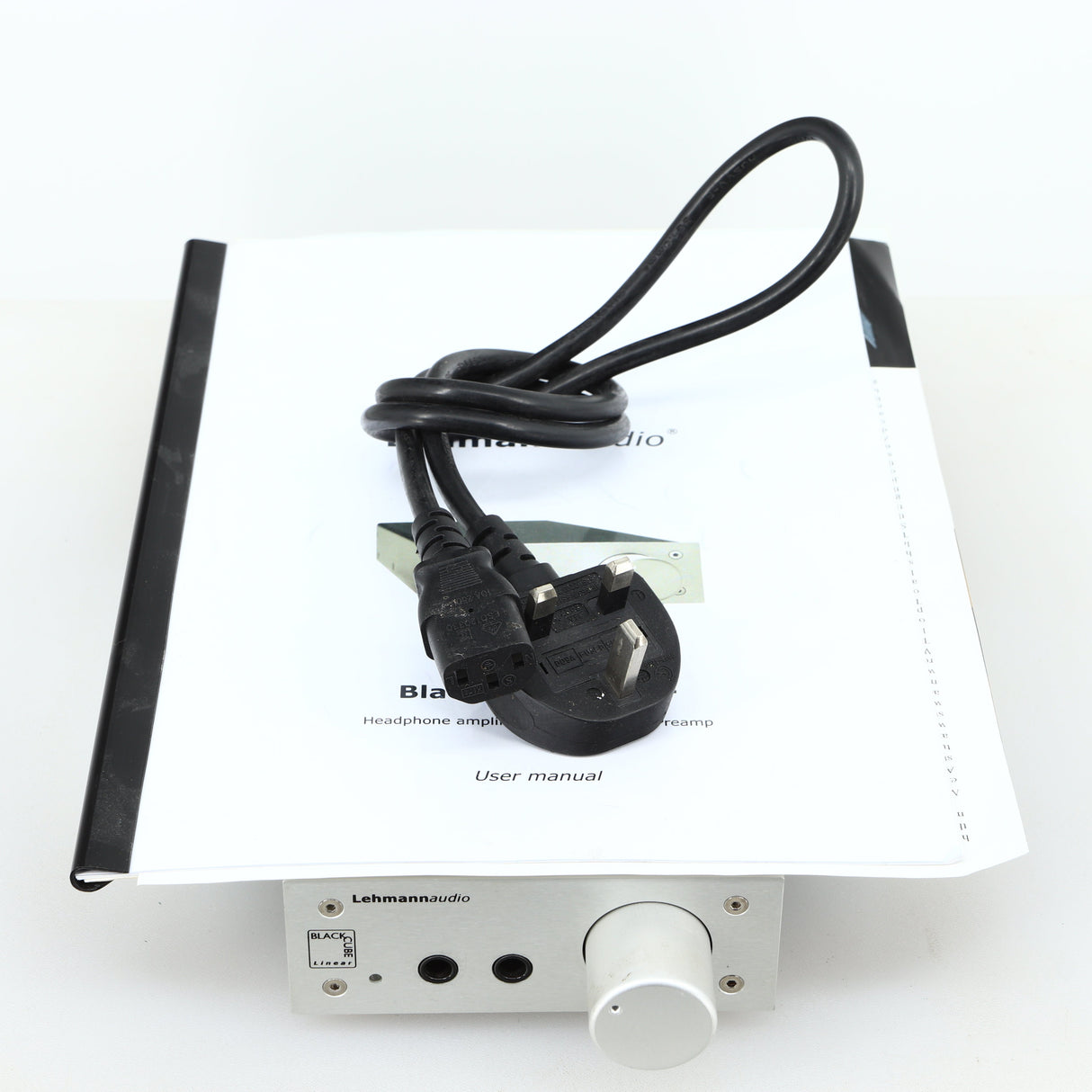 top of a used Lehmann Black Cube Linear Headphone Amplifier in a silver finish showing Mains Cable and Manual