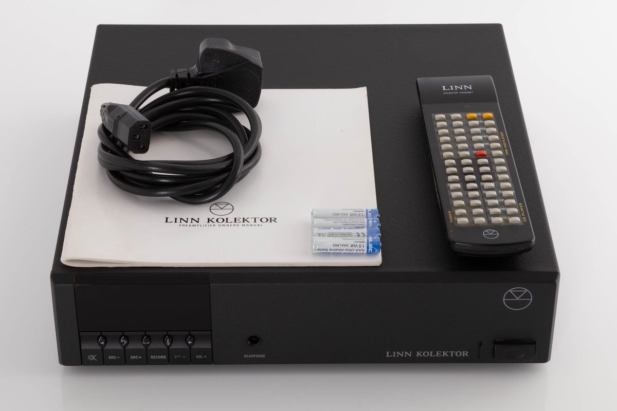 Top of a used Linn Kolektor Pre Amplifier in a Black finish showing Remote, Batteries, Manual and Mains Cable