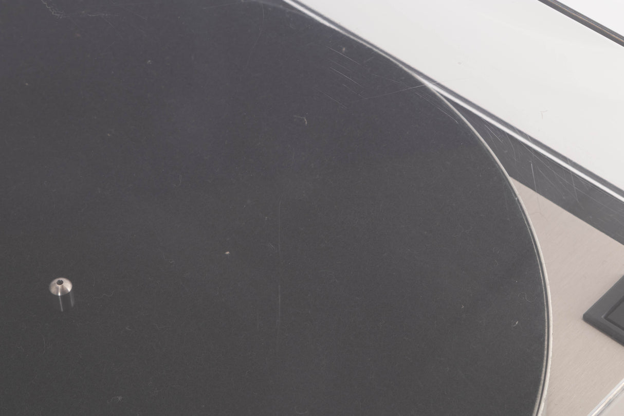 Close up of a used Linn LP12 Turntable / Basik Plus Tonearm / K-9 Cartridge in a Black Ash finish showing scratching on lid