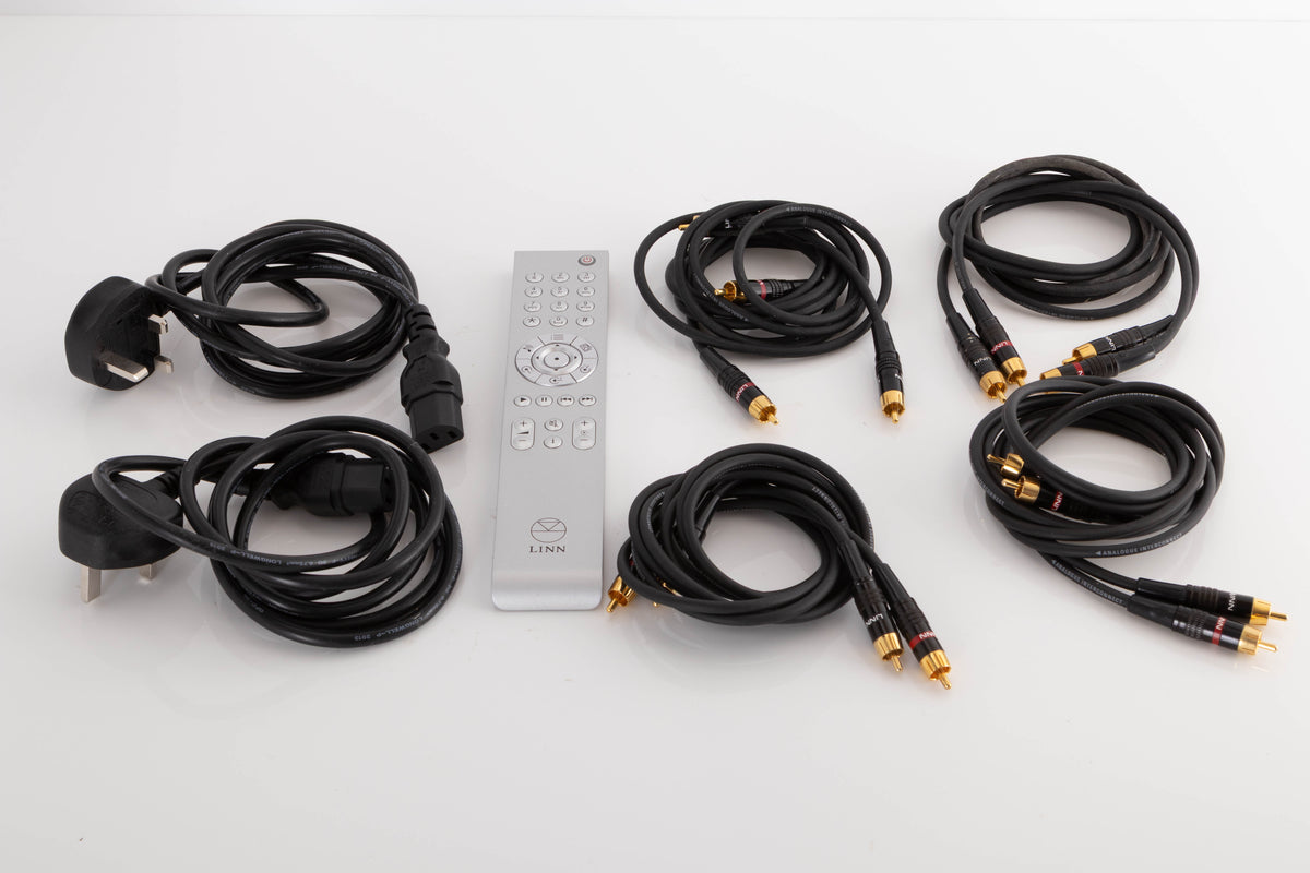 Accessories of a Linn Majik DSM/1 Network Player and Majik 6100 Power Amplifier showing 2x Mains cables, Remote, and 4x RCA Cables