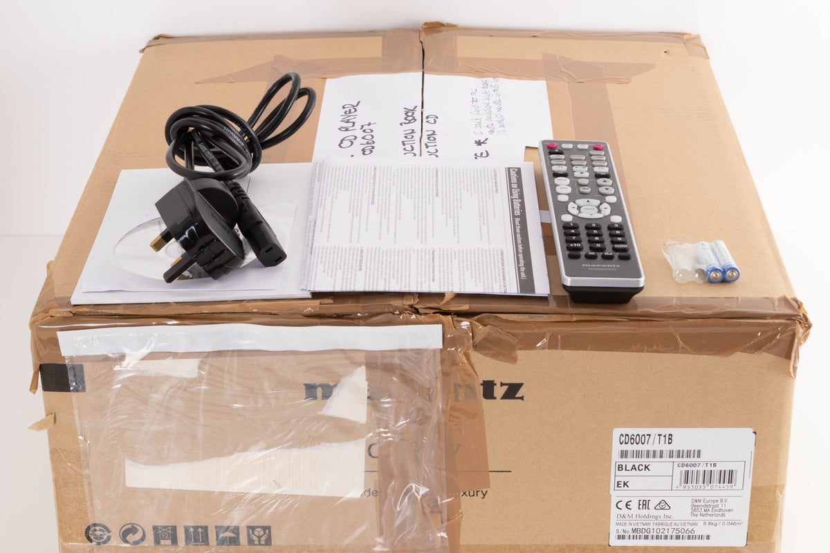 Box for a used Marantz CD6007 CD Player in a Black finish showing Remote, Batteries, Manual and Mains Cable
