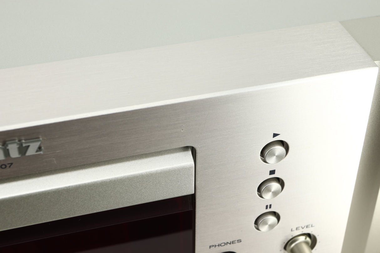 Close up view of a dent on the fascia of a used Marantz CD6007 CD Player in silver finish