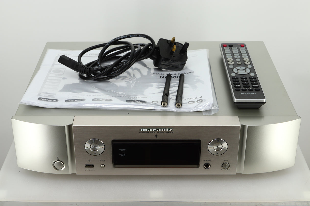 View of accessories of a used Marantz NA6005 Network Player in silver finish showing mains cable, manual, remote, and 2 network antenna