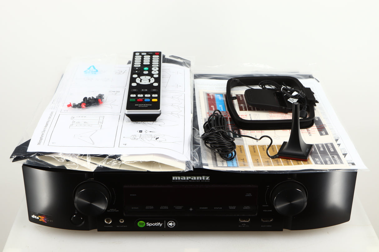 Top of a used Marantz NR1606 AV Receiver in a black finish showing Manual, Microphone Stand, Microphone, Square Loop Antenna and Remote