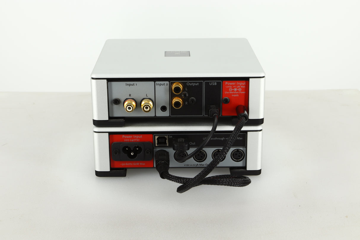 Rear view of a used Meridian Prime Headphone Amplifier and Power Supply in silver finish showing RCA inputs and outputs, mains input, USB input and power connections