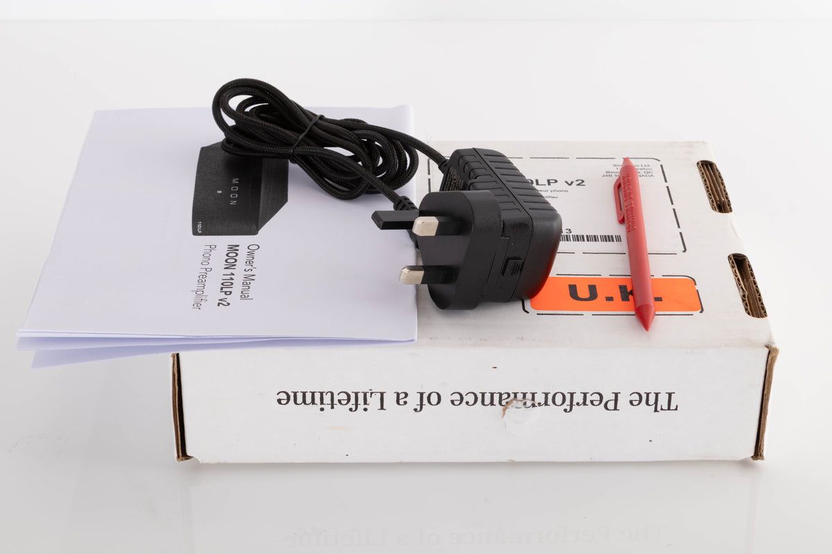 Box of a used Moon 110LP v2 Phonostage with mains cable, manual, and dip stick