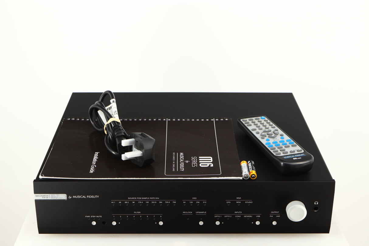 Top of a used Musical Fidelity M6X DAC in a black finish showing Mains Cable, Manual, 2x Batteries and Remote