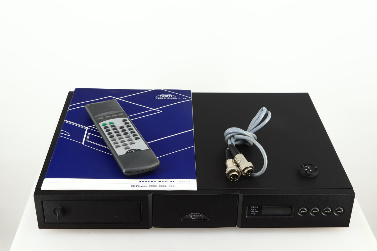 Top a used Naim CD5 CD Player in a black finish showing a manual, cd puck, snaic5 and remote