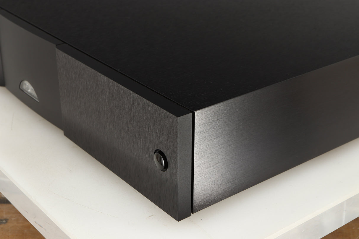 Front right corner of a used Naim CD555PS DR Power Supply in a black finish