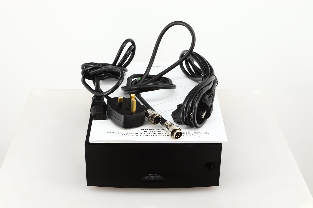 Top of a used Naim Hicap DR Power Supply in a black finish showing Manual, SNAIC5, Mains Cable and Schuko Cable