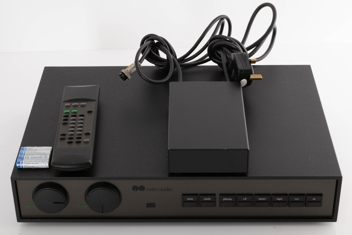 Top of a used Naim NAC102 W/ NAPSC in a Black finish showing Remote and Batteries