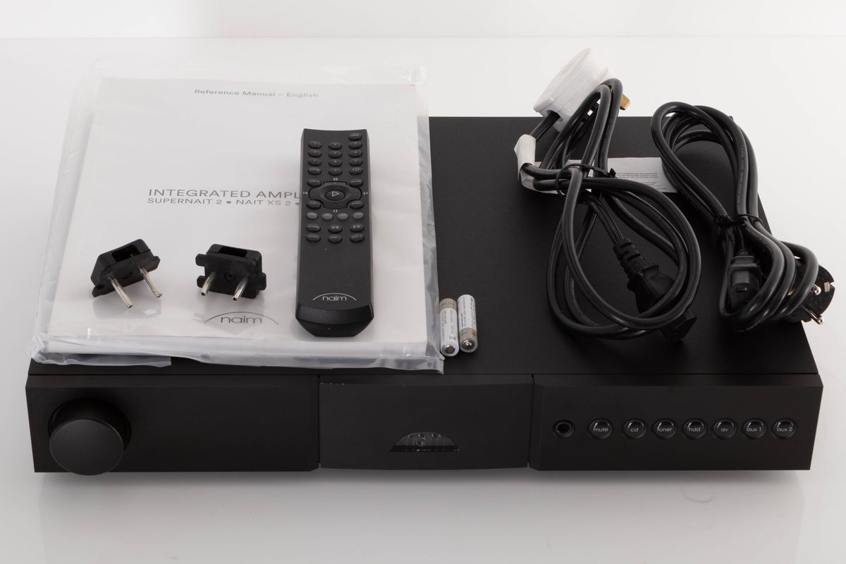 Top of a used Naim Nait XS-2 Integrated Amplifier in a Black finish showing Remote, Batteries, Manual, Link Plugs, Mains Cable and Schuko Cable
