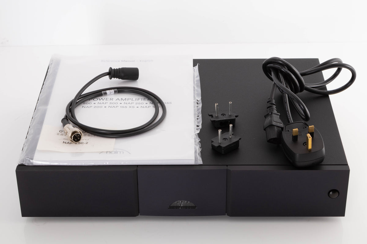 Top of a used Naim NAP250 DR Power Amplifier in a Black finish showing Manual, SNAIC4, Mains Cable and Link Plugs
