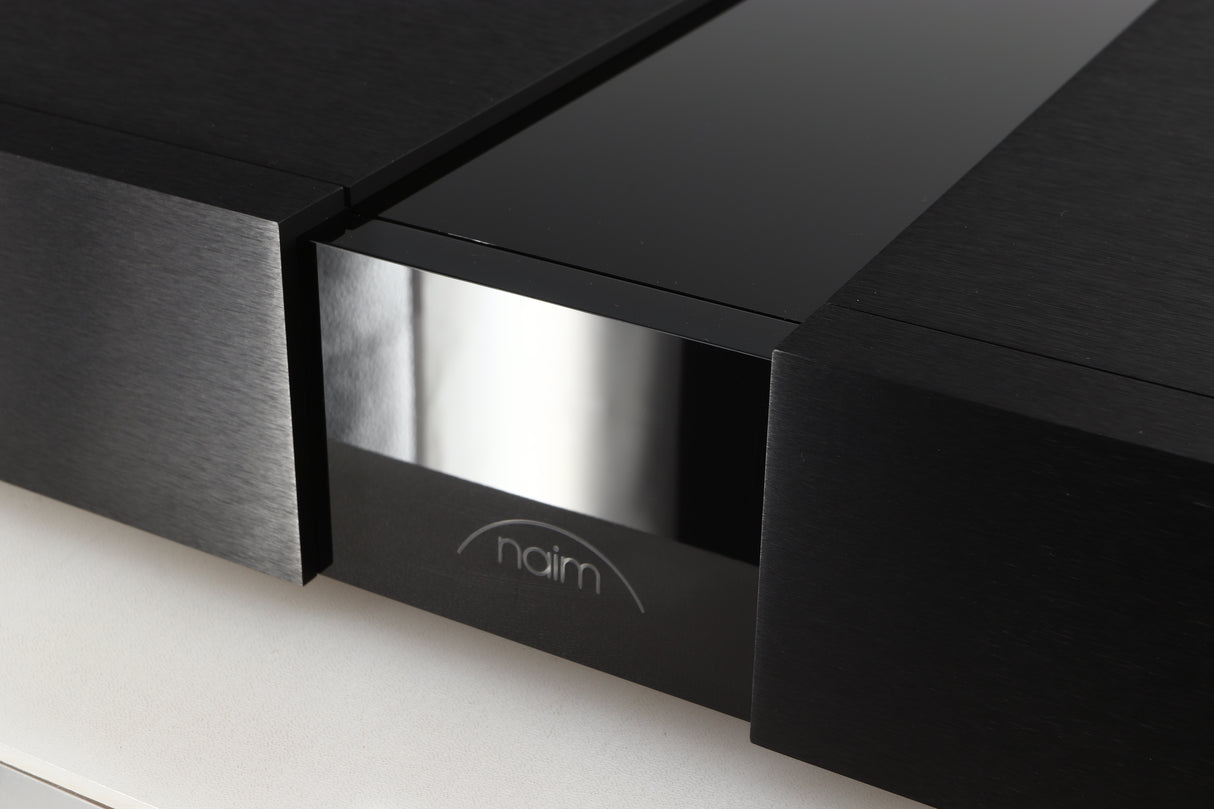 Close up of a used Naim NPX300 Power Supply in a black finish showing scratching on logo