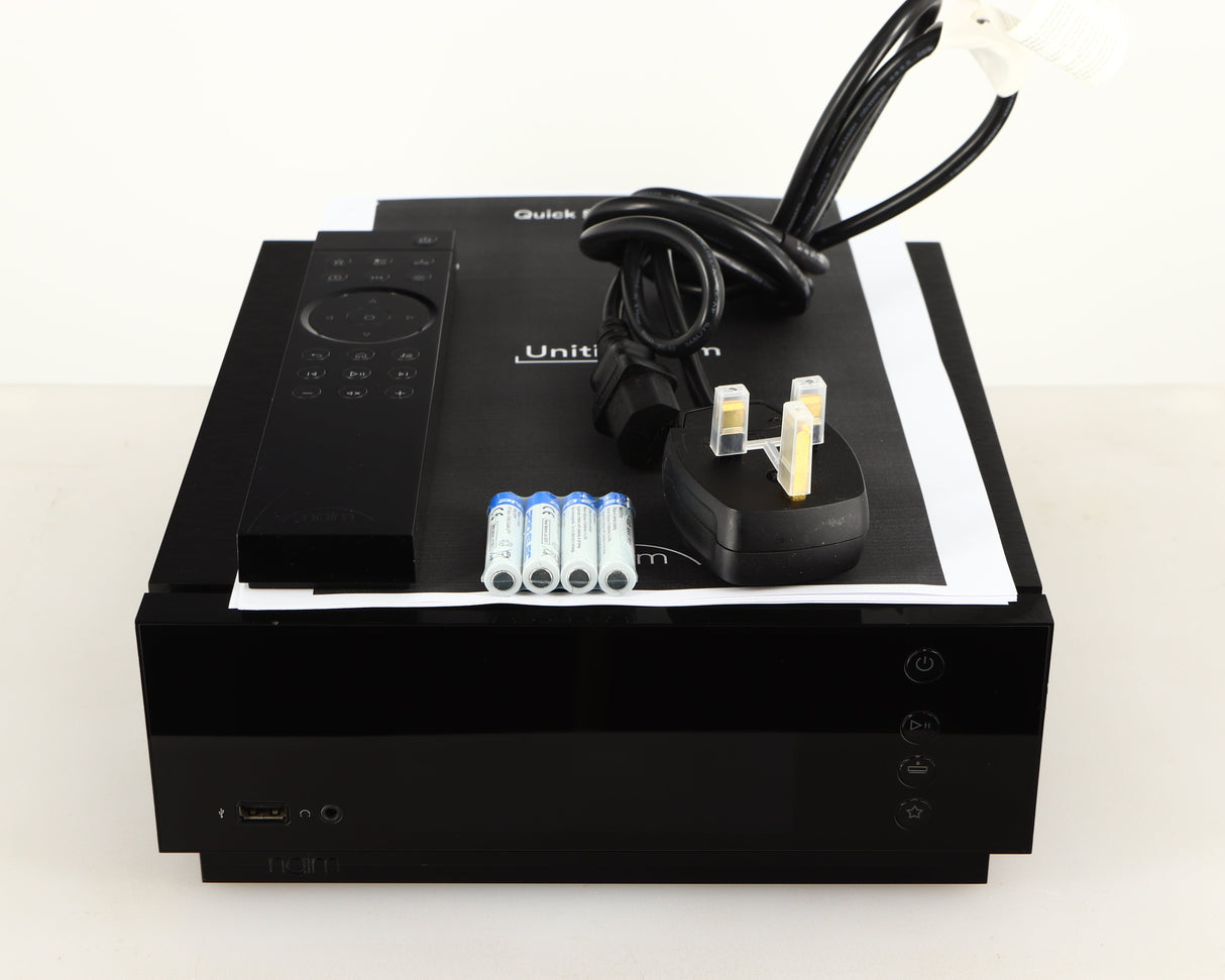Top of a used Naim Uniti Atom HDMI Integrated System in a black finish showing Mains Cable, Manual, Remote and Batteries