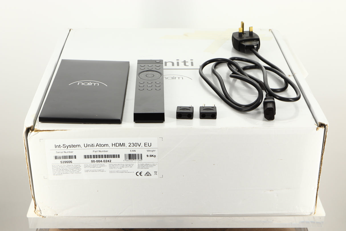 Box of a used Naim Uniti Atom HDMI Integrated System with mains cable, manual, remote, and speaker plugs