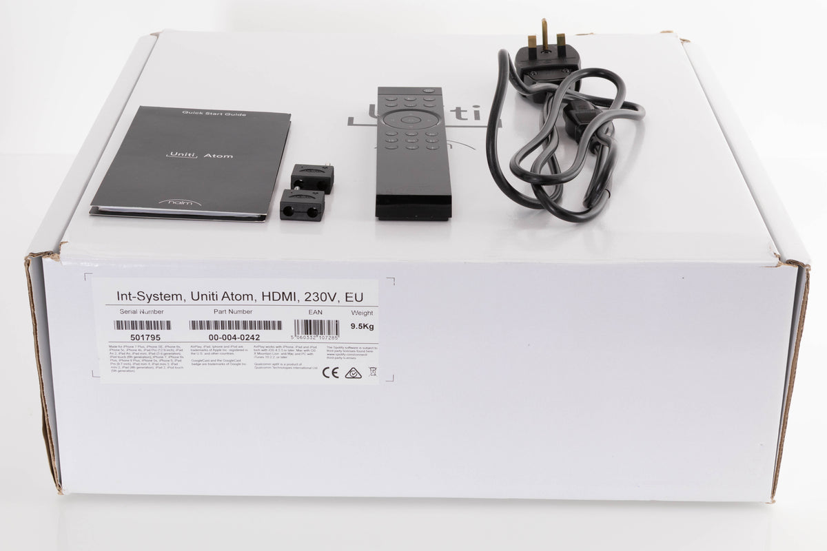 Box of a used Naim Uniti Atom Streaming Music System with mains cable, manual, remote, and 2x speaker plugs