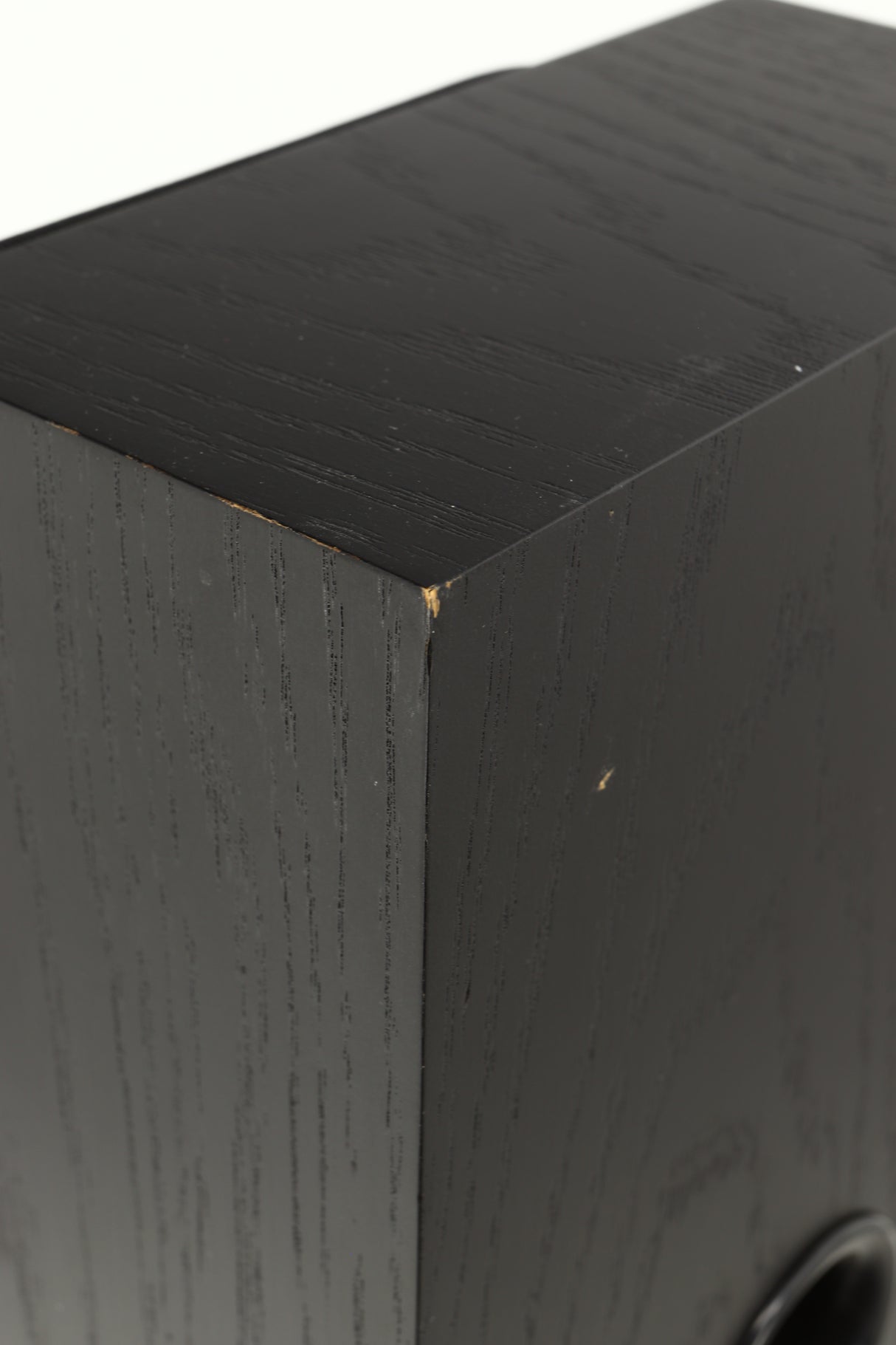 Close up view of a used NEAT Acoustics Iota Alpha Floorstanding Speaker in Black Oak finish showing damage to the paint on the back corner