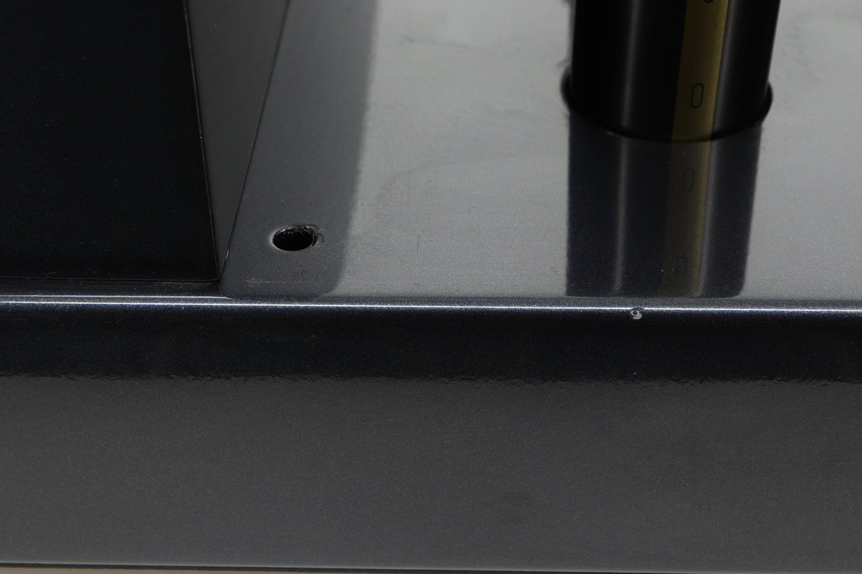 Close up view of a used PrimaLuna Prologue Premium Pre Amplifier in Black finish showing a small chip on the left side and that the back left rubber washer is missing
