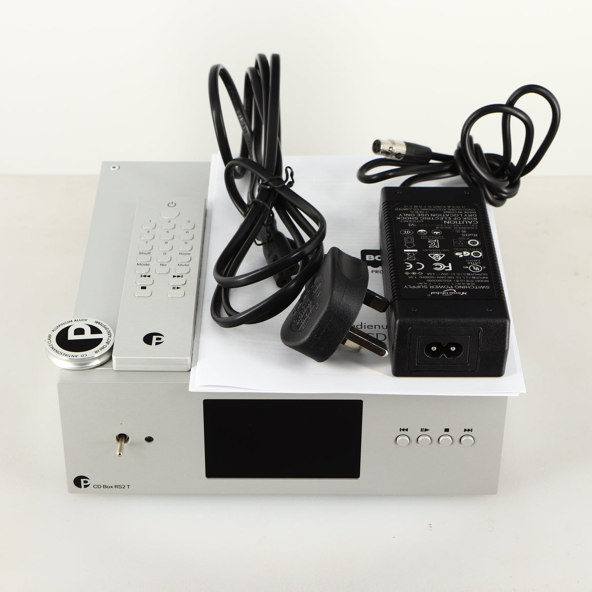 Top of a used Project CD Box RS2 T CD Transport in a silver finish showing PSU, Power Cable, Manual, Remote and Clamp