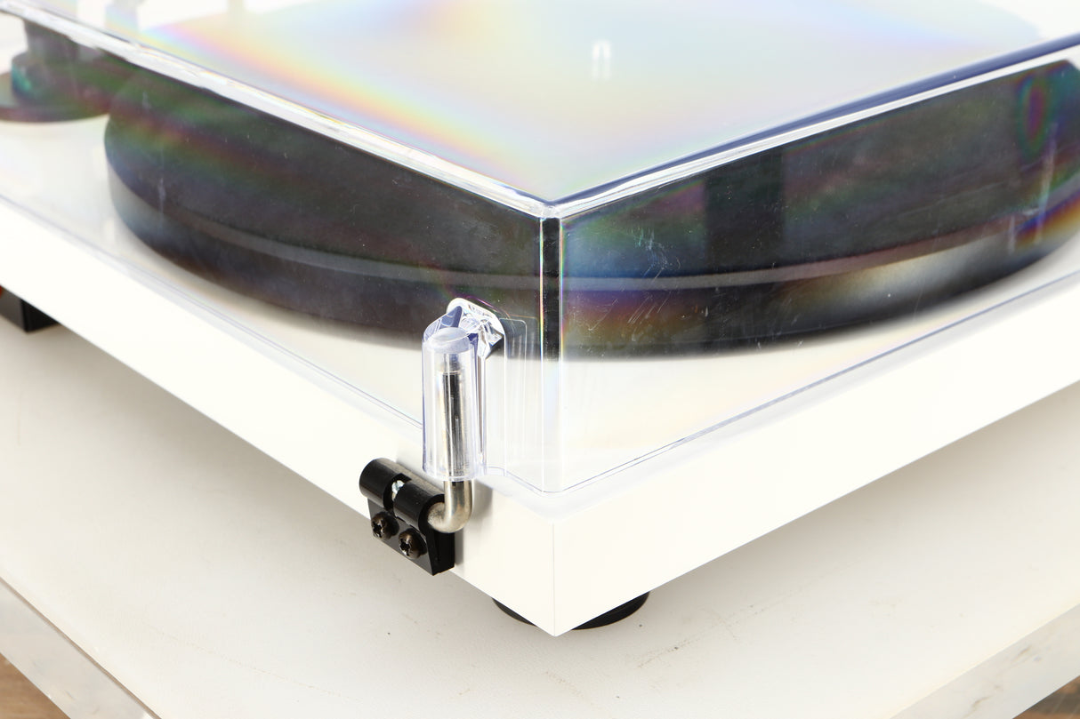 Rear left corner of a used Project Debut Carbon Turntable / Ortofon 2M Blue Cartridge in a white finish