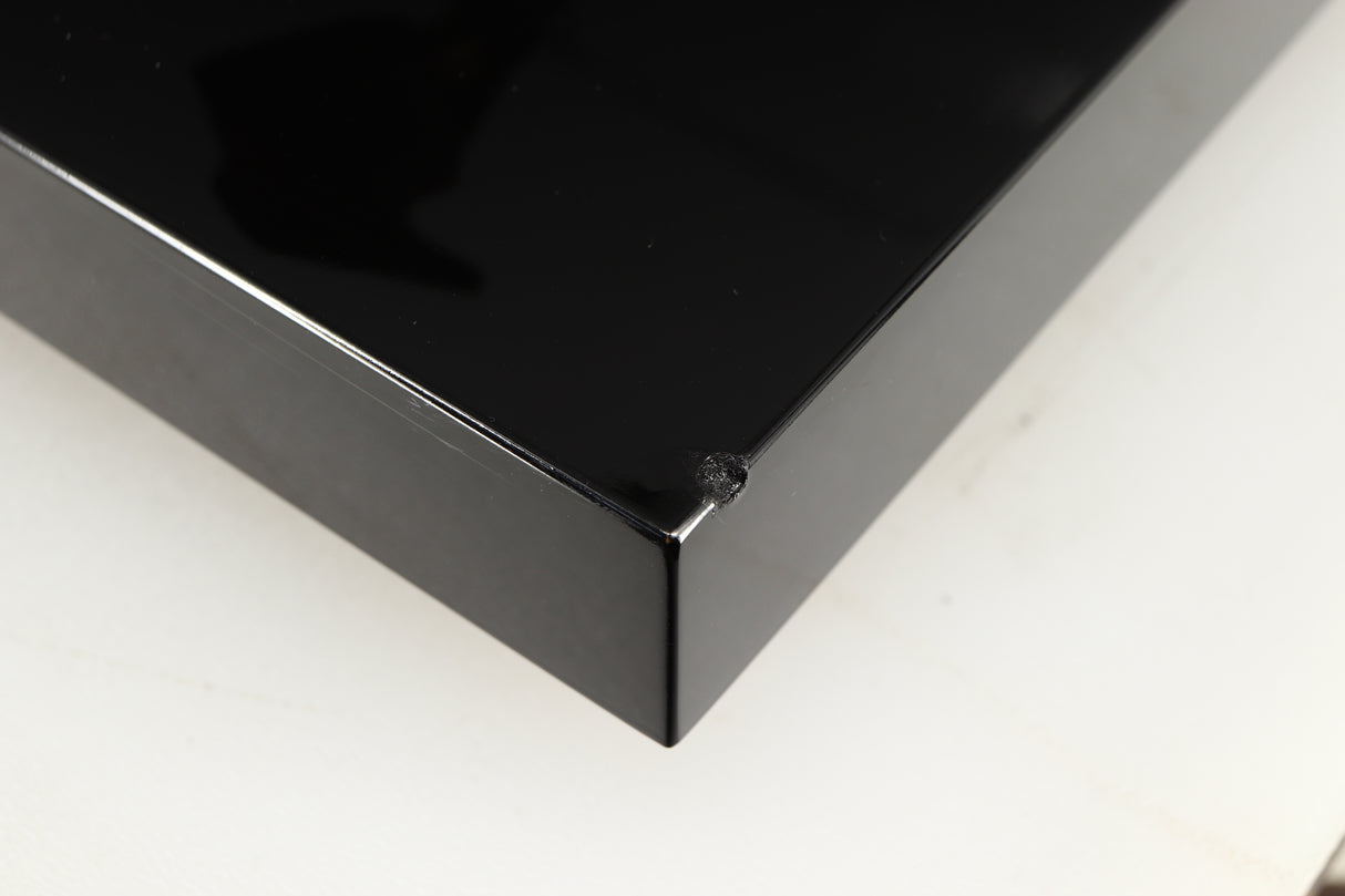 Close up of a used Project Debut Carbon Turntable in a piano black finish showing chip on front right corner