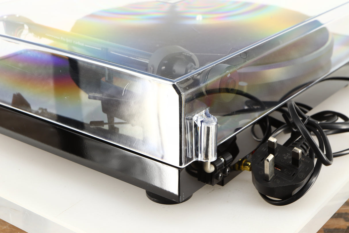 Rear right corner of a used Project Debut Carbon Turntable in a piano black finish