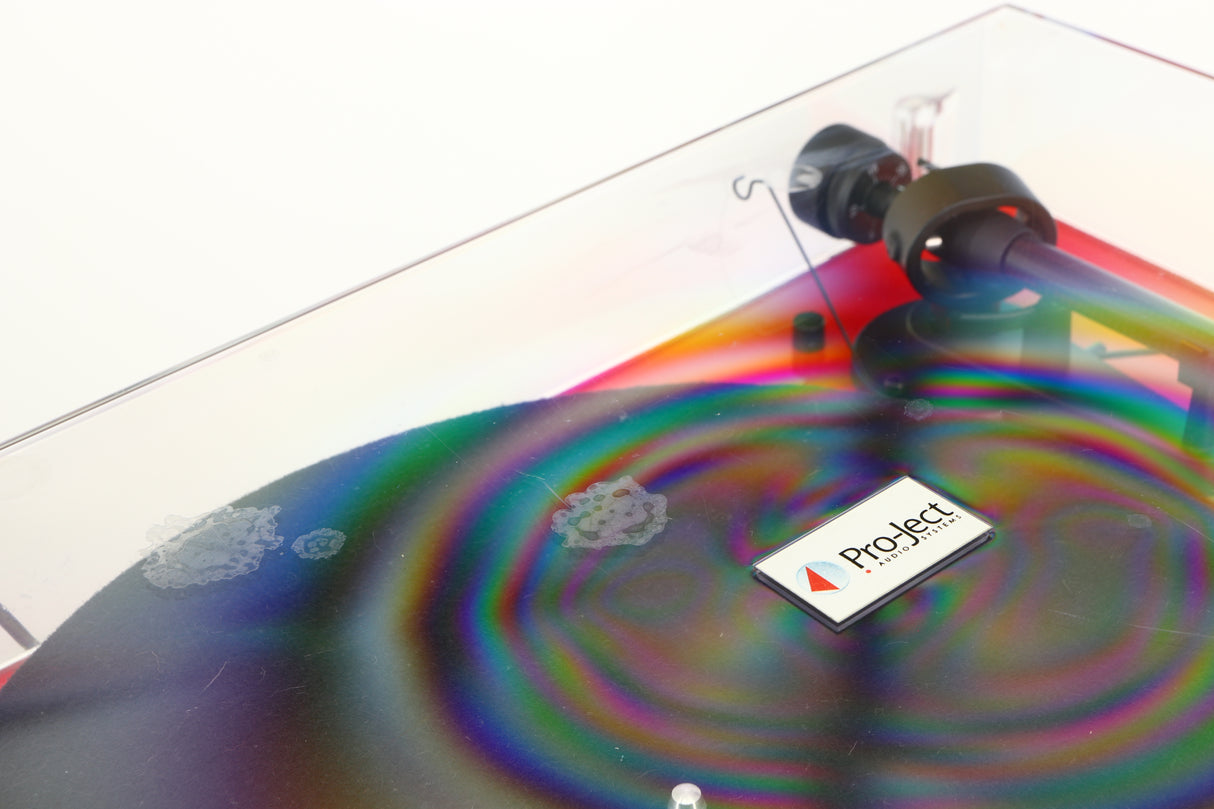 Close up of a used Project Debut Carbon Turntable in a red finish showing marks on top of lid