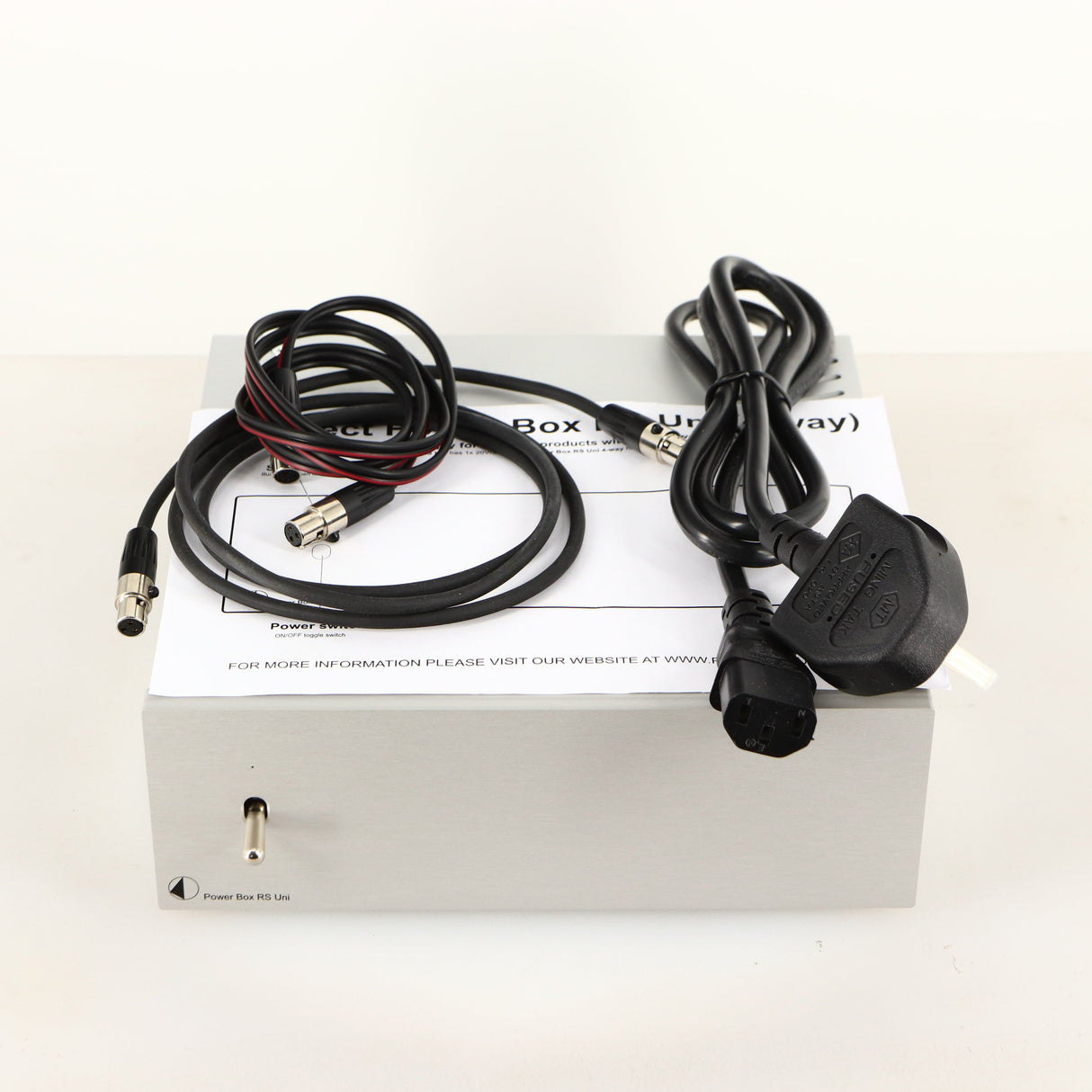 Top of a used Project Power Box RS Uni-1-Way Power Supply in a silver finish showing Mains Cable, Manual and Project Connect It Power Cable