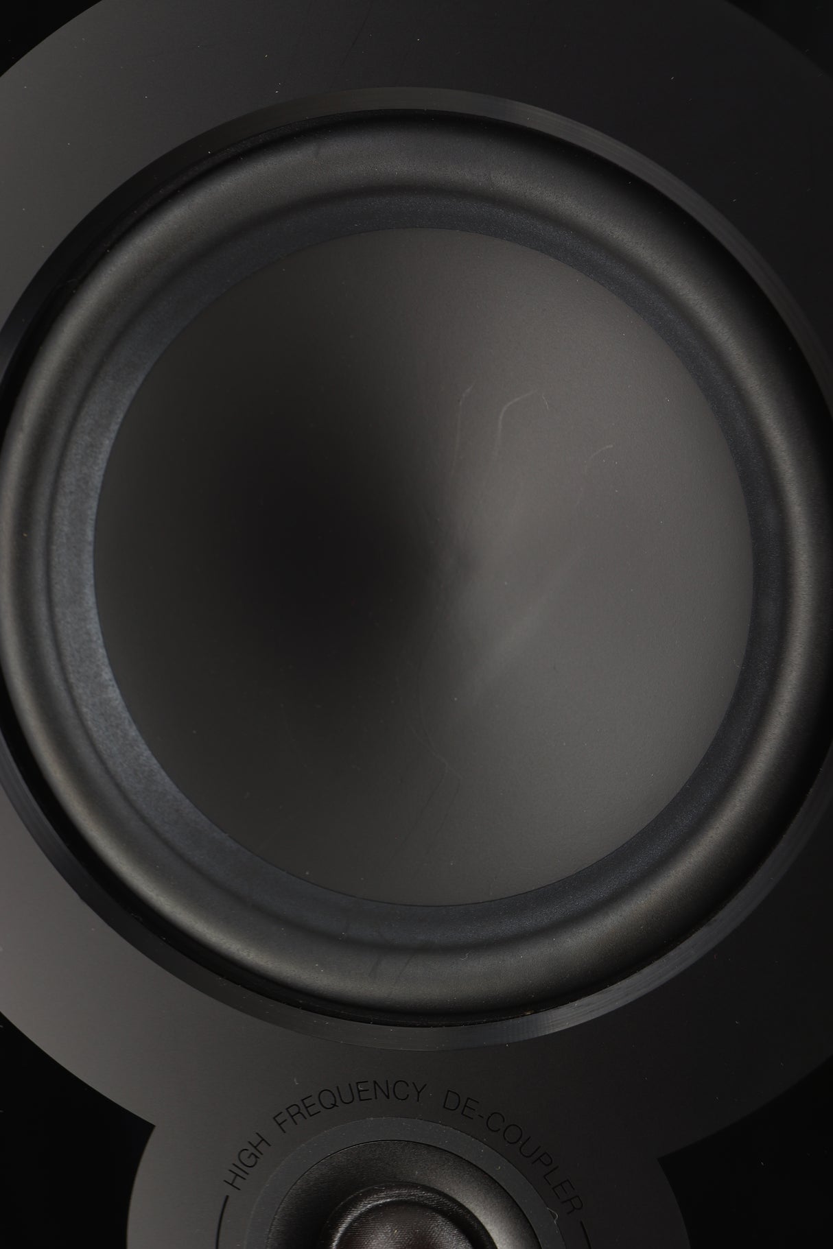 Close up of a used Q Acoustics 5050 Floorstanding Speaker in an oak finish showing scratching on bass driver