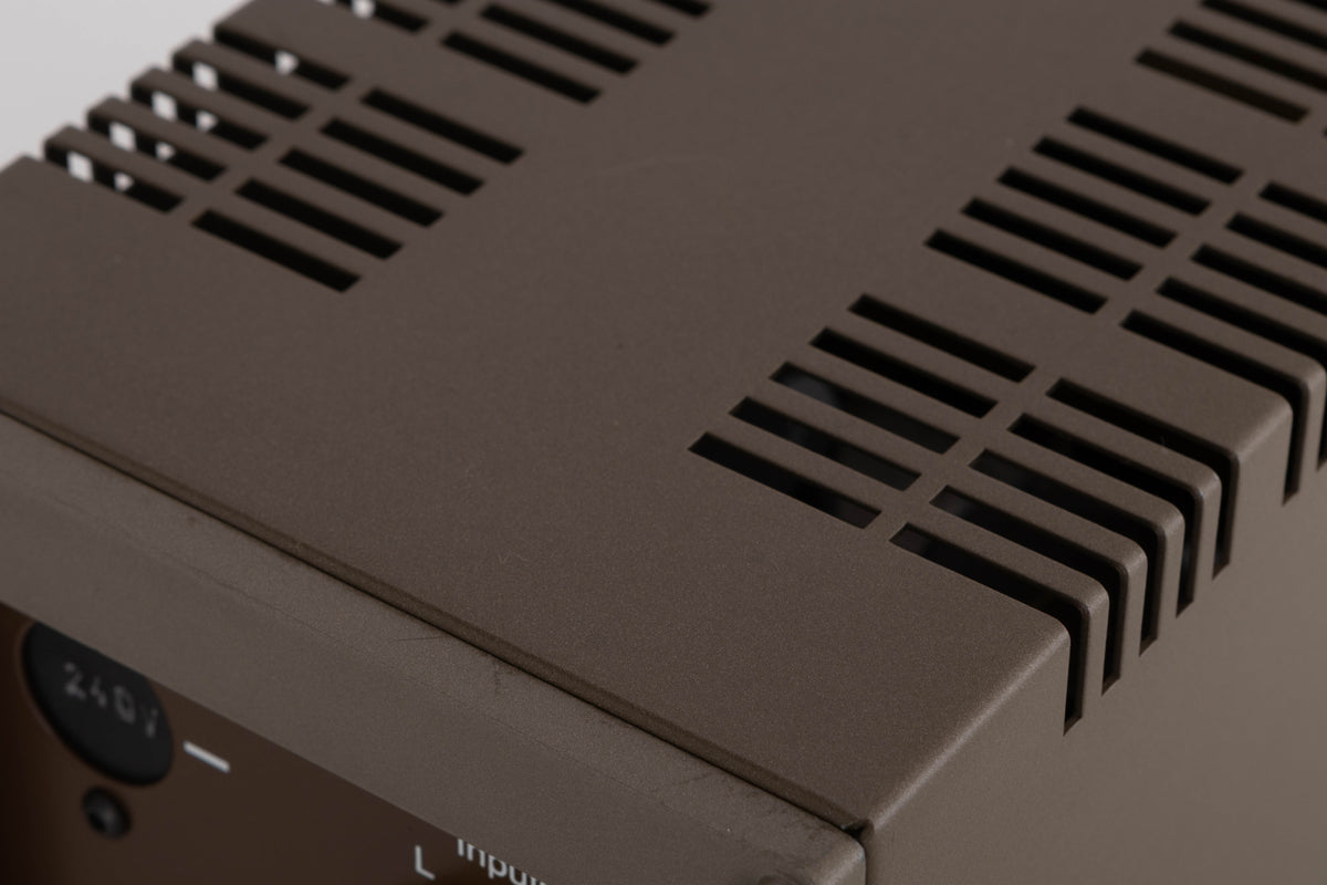 Close up of a used Quad 303 Power Amplifier showing scratching on rear edge