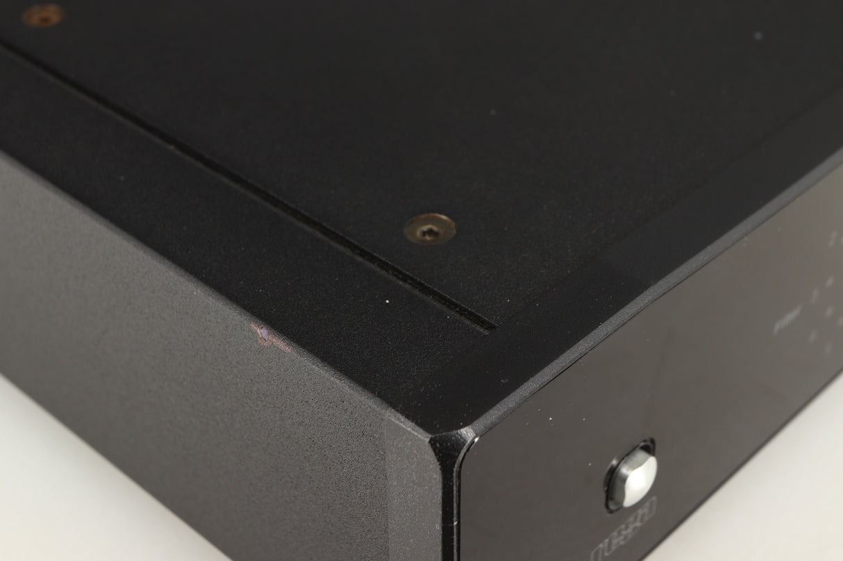 Close up of a used Rega DAC Digital Analogue Converter in a black finish showing small nick on left side edge