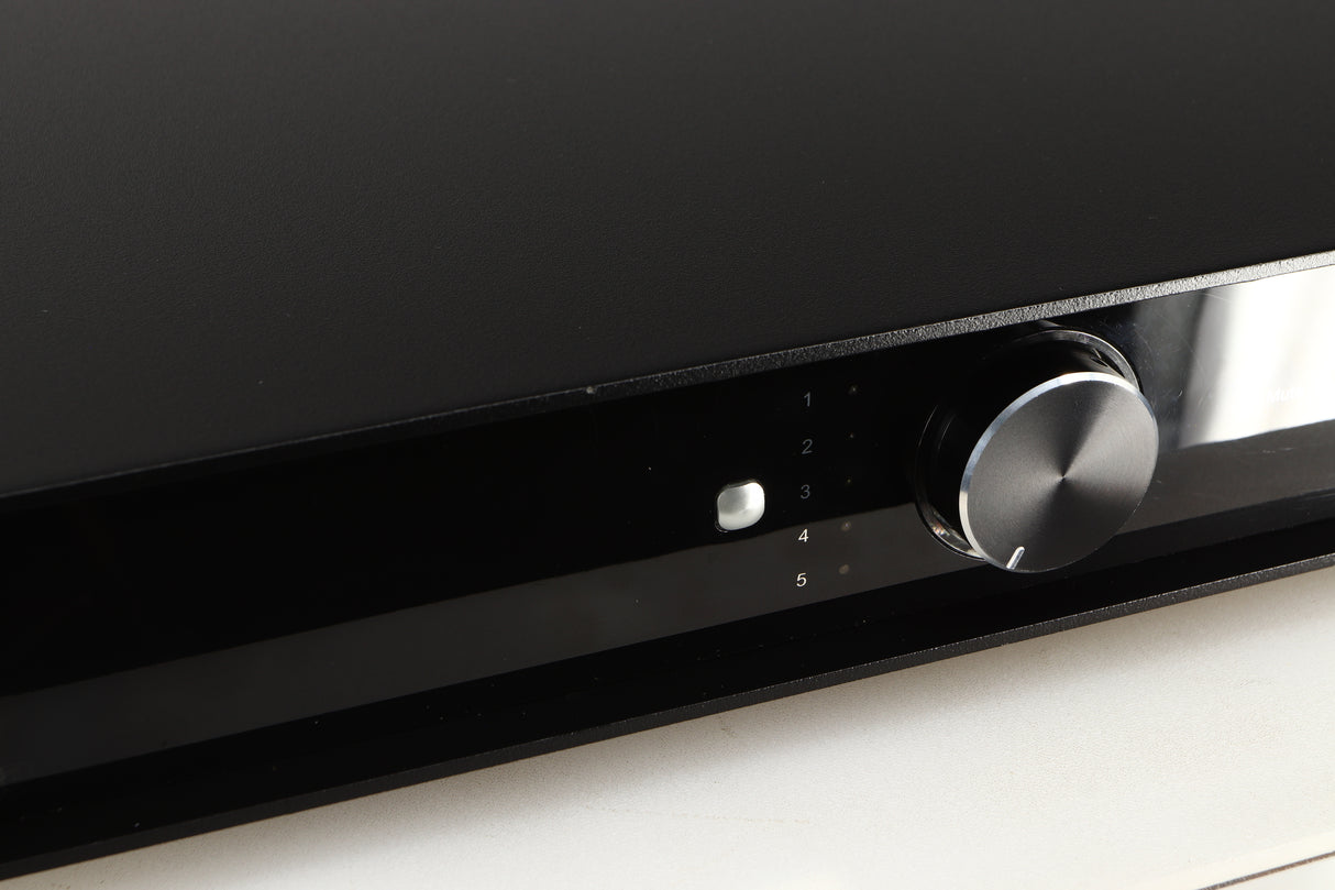 Close up of a used Rega Elex-R Integrated Amplifier in a black finish showing scratches and marks on screen
