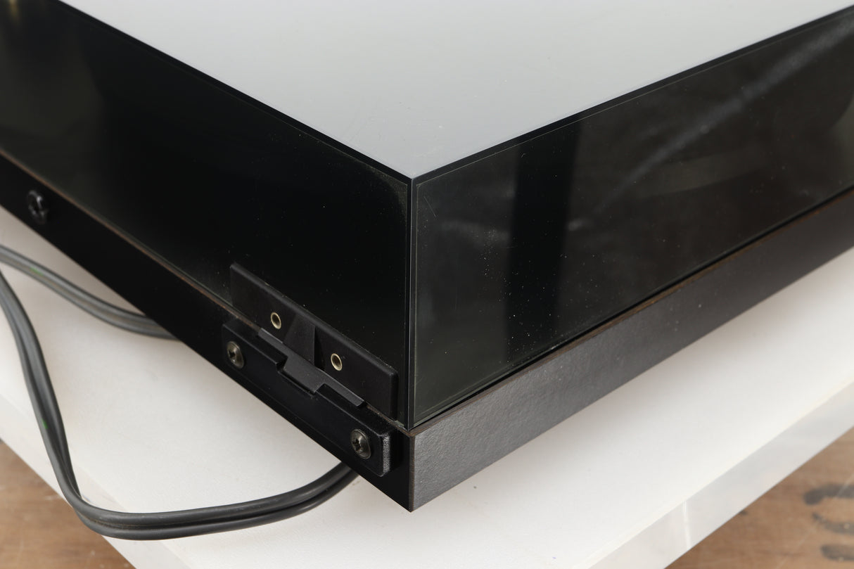 Rear left corner of a used Rega Planar 3 Turntable 24V Upgraded in a black finish