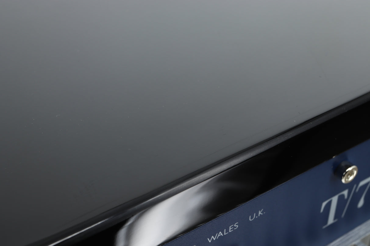 Close up of a used REL T-7X Subwoofer in a piano black finish showing some scratches