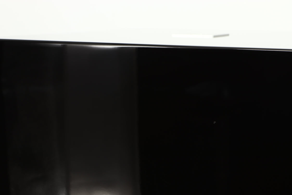 Close up of a used REL T5i Subwoofer W/ Upgraded Feet in a piano black finish showing small nick